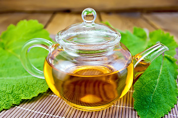 Image showing Tea in teapot with sage on bamboo napkin