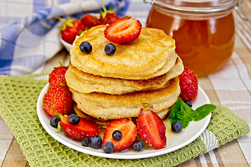 Image showing Flapjacks with strawberries and blueberries with napkin
