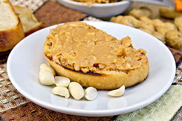 Image showing Sandwich with peanut butter and nuts in bowl on napkin