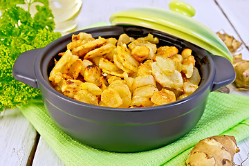 Image showing Jerusalem artichokes roasted in pan with lid on light board