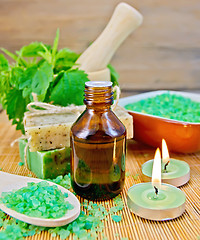Image showing Oil and candle with nettles in mortar on board