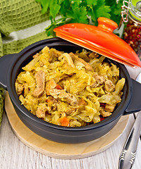 Image showing Cabbage stew with meat in black pot on board