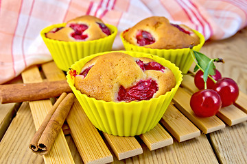 Image showing Cupcakes with cherries in tins on board