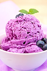 Image showing Ice cream blueberry with mint in bowl on napkin