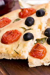 Image showing Focaccia with black olives, tomatoes and basil