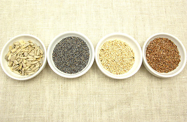 Image showing Four bowl with different seeds on a beige background