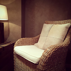 Image showing Classic rattan armchair and cozy lamp