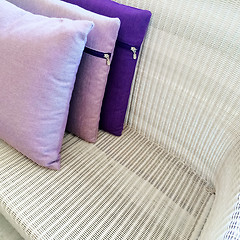 Image showing Purple cushions decorating rattan sofa