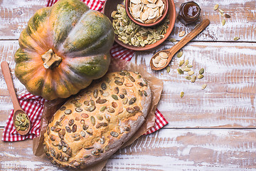 Image showing Newly baked bread with pumpkin and seeds wooden table