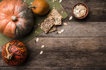 Image showing Rustic pumpkins with seeds and cookies on wooden table