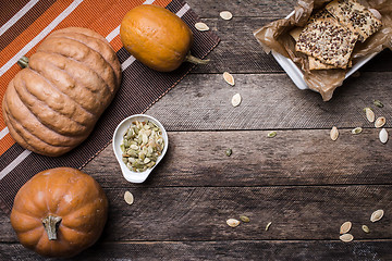 Image showing pumpkins with cookies and seeds on wooden table 