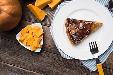 Image showing pie on plate and pieces of pumpkin in Rustic style