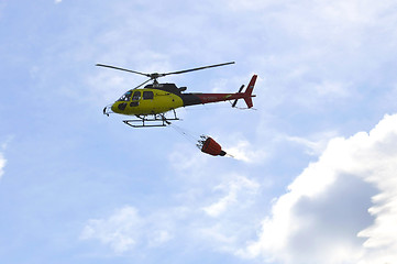 Image showing The small yellow helicopter of Utair airline in the sky.