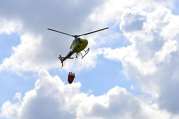 Image showing The small yellow helicopter in the sky.