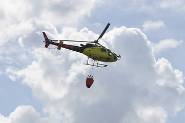 Image showing The small yellow helicopter of Utair airline in the sky.