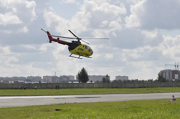 Image showing The small yellow helicopter of Utair airline in the sky