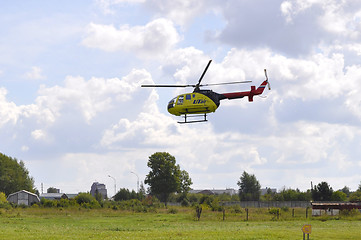 Image showing The small yellow helicopter of Utair airline in the sky.