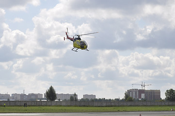 Image showing The small yellow helicopter in the sky.