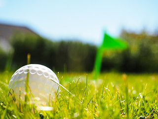 Image showing Golf ball laying in rough green grass approaching the tee with g