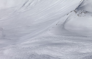Image showing Off-piste slope with traces of skis and snowboards in sun day