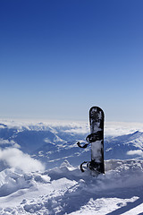 Image showing Snowboard in snow on off-piste slope at sun day