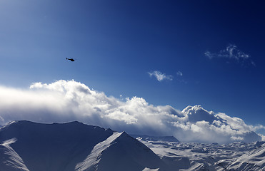 Image showing Helicopter above snowy plateau in evening