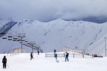 Image showing Ski slope with skiers and snowboarders in evening