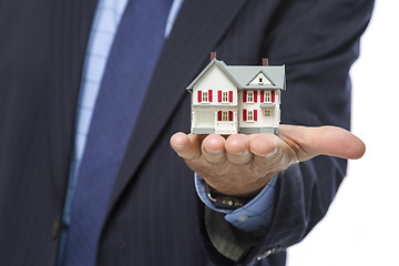 Image showing Male Real Estate Agent Holding Miniature House in Palm