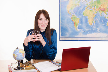 Image showing The manager of travel agency is drinking tea in workplace