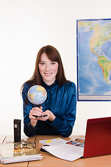 Image showing Geography teacher at the table with a globe in his hands