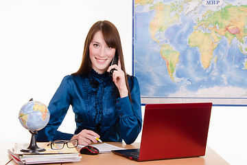 Image showing Travel agency employee is talking to a customer on the phone