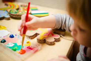 Image showing Little female baby painting with colorful paints