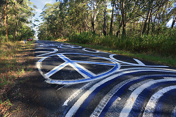 Image showing Peace Odyssey - peace signs grafitti on the road painted Seal Ro