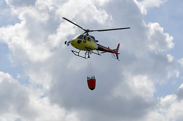 Image showing The small yellow helicopter in the sky.