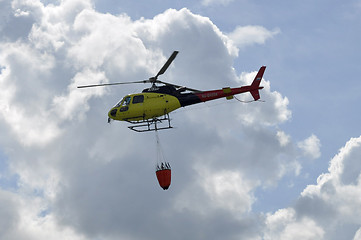 Image showing The small yellow helicopter in the sky.