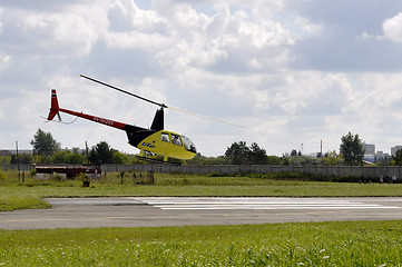 Image showing The small yellow helicopter in the sky.