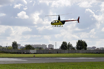 Image showing The small yellow helicopter in the sky.