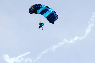 Image showing the parachutist goes down on a multi-colored parachute.