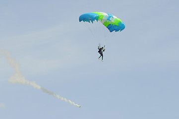 Image showing the parachutist goes down on a multi-colored parachute.