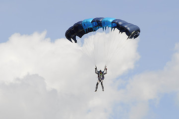 Image showing the parachutist goes down on a multi-colored parachute.