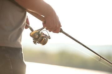 Image showing Modern clean fishing rod in hands