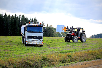 Image showing Stacking up Silage onto a Volvo FH12 Flatbed Truck