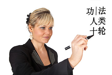 Image showing Studio portrait of a cute blond girl writing on a transparent wa