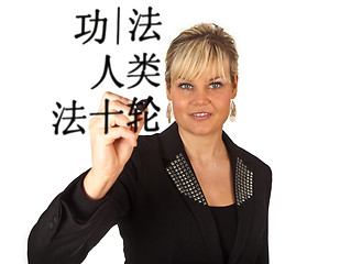 Image showing Studio portrait of a cute blond girl writing on a transparent wa