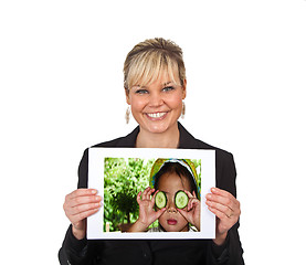 Image showing Studio portrait of a cute blond girl holding a piece of paper