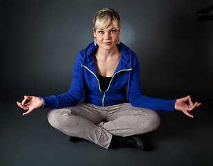 Image showing Studio portrait of a cute blond girl in a meditation position