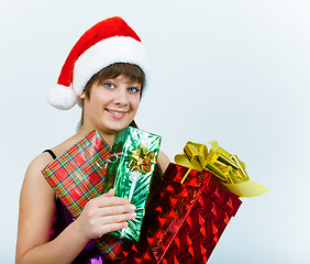 Image showing young woman in santa hat with gift box