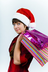 Image showing young woman in santa hat with holiday shopping