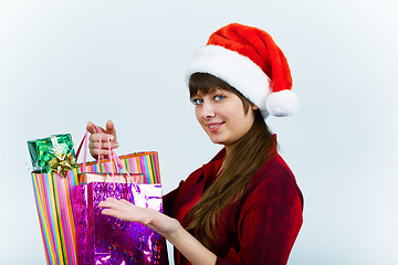 Image showing young woman in santa hat with holiday shopping