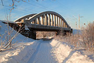 Image showing The railway bridge over winter road